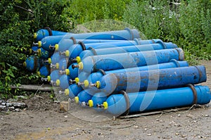 Blue industrial oxygen cylinders on the ground in the mud Unsafe storage of industrial waste