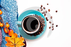 Blue instant coffee Cup on saucer and beans on warm cozy plaid on white background close up, copy space top view flat lay, autumn