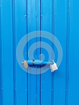 blue iron door closed with two padlocks, closed doors