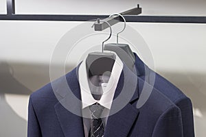 Blue jacket on a hanger, close-up front view, in the men`s clothing store