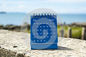 Blue January 2024 calendar on blurred background of blue ocean
