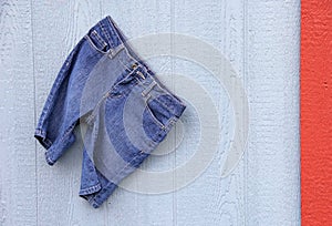 Blue Jean Capri Shorts on blue grey wall red border