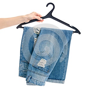 Blue jeans on hanger in hand