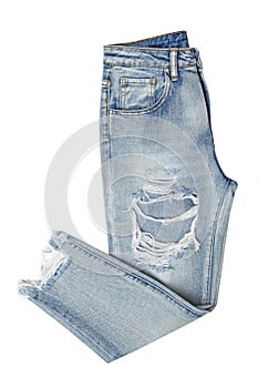 Blue jeans with holes folded in two isolated on white background