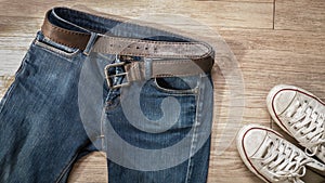 Blue jeans with leather belt and dirty white sneaker shoes on t photo