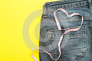 Blue jeans with measure tape in pocket in form of a heart. concept of healthy lifestyle and diet with love to your body