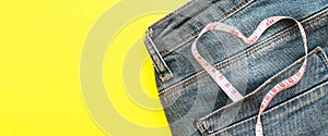 Blue jeans with measure tape in pocket in form of a heart. concept of healthy lifestyle and diet with love to your body