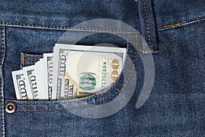 Blue jeans pocket with hundred dollars banknotes