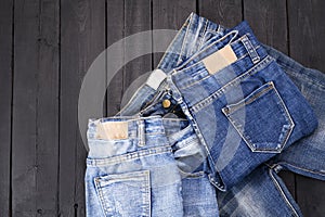 Blue jeans resting on a black wooden floor. modern fashion jeans
