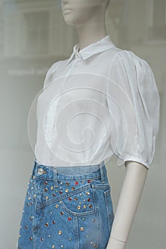 blue jeans skirt and whote shirt on mannequin in a fashion store showroom