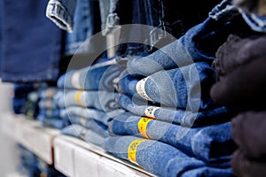 Blue jeans are stacked on a shelf