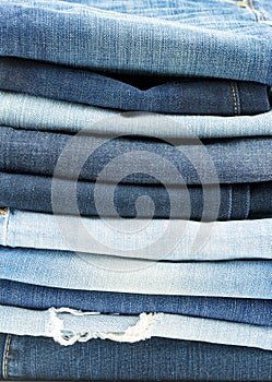 Blue jeans trousers stack on white background