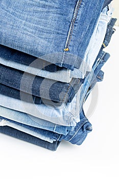 Blue jeans trousers stack on white background
