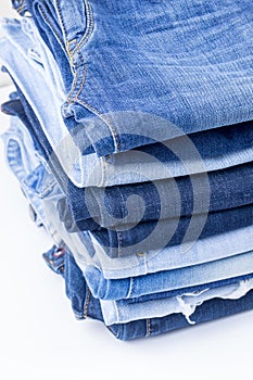 Blue jeans trousers stack on white background