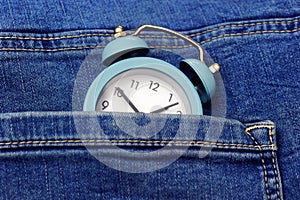 Blue jeans and vintage blue alarm clock like a time concept