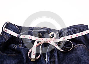 Blue Jeans and white measuring tape on white background.