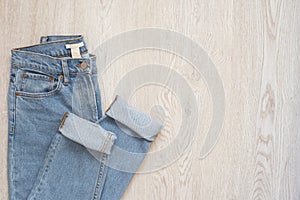 Blue jeans on a wooden background. Flat lay of female styled look. Top view. Shopping Concept. Fashion Outfits