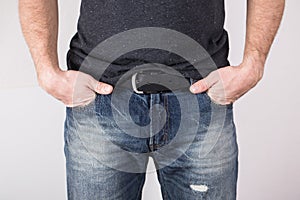 Blue jeans of a young man wearing grey blank t-shirt