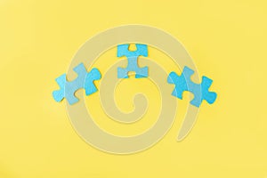 Blue jigsaw puzzle pieces on yellow background. Teamwork  logical thinking. Concept of solutions, mission, success, goals,