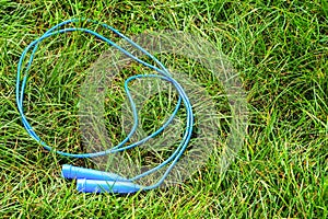 Blue jump rope on a green grass. The Destky sports igursha on a lawn