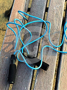 Blue jump rope is lying on the bench sports equipment