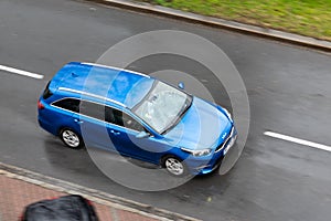 Blue Kia Ceed SW Sportswagon estate car in rainy day with motion blur effect