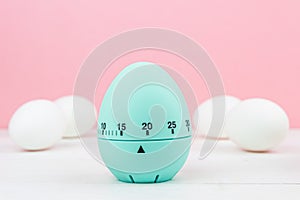 Blue kitchen egg timer on a pink background. cooking time, soon Easter