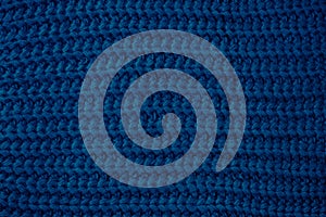 Blue knitted texture, dark fabric background. Color 2020, trends fashion. Woolen sweater, backdrop clothing