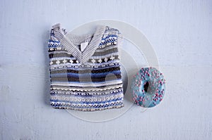 Blue knitted waistcoat for a baby with a blue glazed donut.