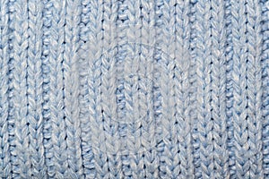 Blue knitted wool fabric background. Very warm natural knitwear handmade