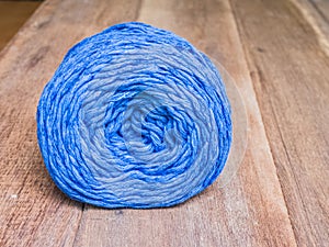 Blue knitting yarn on wooden background