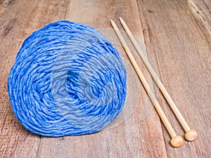 Blue knitting yarn on wooden background