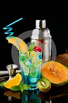 Blue Lagoon cocktail with a slice of melon and cherry isolated on white