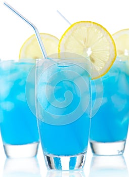 Blue lagoon cocktails with slice of lemon with straw isolated on white