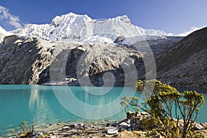 Blue lake in foot of snow-covered mountain at sunrise
