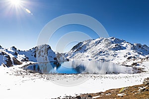 Blue lake mountains covered snow, Gosaikunda Nepal.