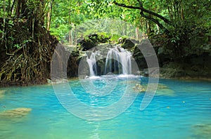 Blue lake and small waterfall. Bright exotic nature with fresh water stream.