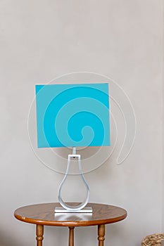 Blue lampshade isolated on beige wall background.Table lamp in turquoise and gray colours.modern living room.Interior of