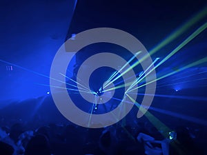 Blue laser light criss crossing a dark room over a crowd. photo