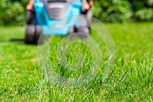 Blue lawn mower on green grass cut the grass