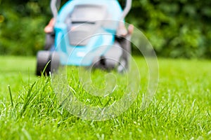 Blue lawn mower on green grass cut the grass