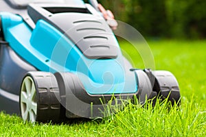 Blue lawn mower on green grass cut the grass