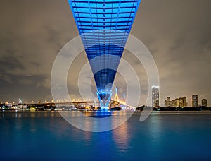 Blue led light under the bridge over the river On a cloudy day in the sky. Bhumibol Bridge, Samut Prakan, Thailand