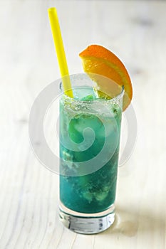 Blue lemonade in glass with ice and lemon