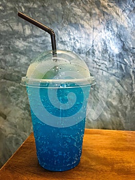 Blue lemonade with soda in takeaway plastic cup