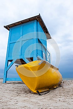 A blue lifeguard booth on the beach on a cloudy day.