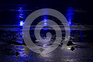 The blue light from the lanterns reflects in the river.