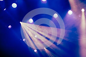 Blue light rays from the spotlight through the smoke at the theater or concert hall. Lighting equipment for a performance or show