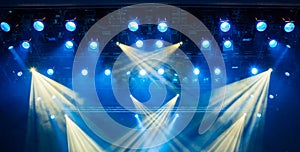 Blue light rays from the spotlight through the smoke at the theater or concert hall. Lighting equipment for a performance or show