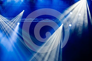 Blue light rays from the spotlight through the smoke at the theater or concert hall. Lighting equipment for a performance or show